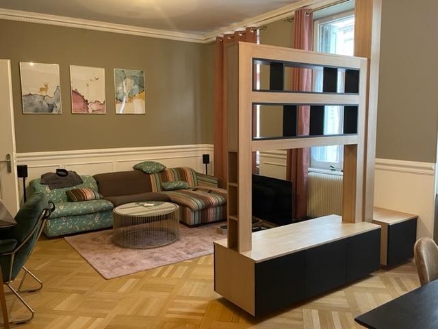 Bibliothèque sur mesure en bois avec niches ouvertes, intégrée à un espace de vie